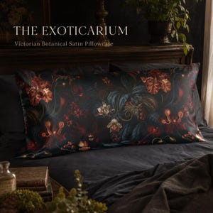 May include: A rectangular satin pillowcase featuring a dark, moody botanical print with deep red, orange, and dark green floral and foliage patterns. The text THE EXOTICARIUM Victorian Botanical Satin Pillowcase is printed above the pillowcase.