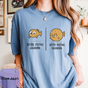 May include: A blue t-shirt featuring a graphic of two pufferfish. The left fish is labeled BEFORE VISITING GRANDMA, and the right, larger, rounder fish is labeled AFTER VISITING GRANDMA. The design uses black text and outlines on the blue fabric.