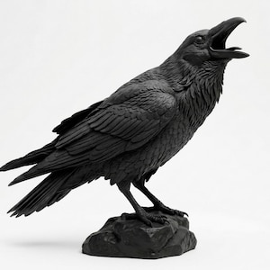 May include: A matte black raven sculpture standing on a textured rock base. The bird is depicted in a profile view with its head tilted upward and its beak wide open, showcasing detailed feather textures across its wings, body, and neck area.