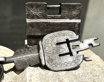 Cadeado de ferro gravado em estilo antigo com chave grande, típico do sul da Ásia.