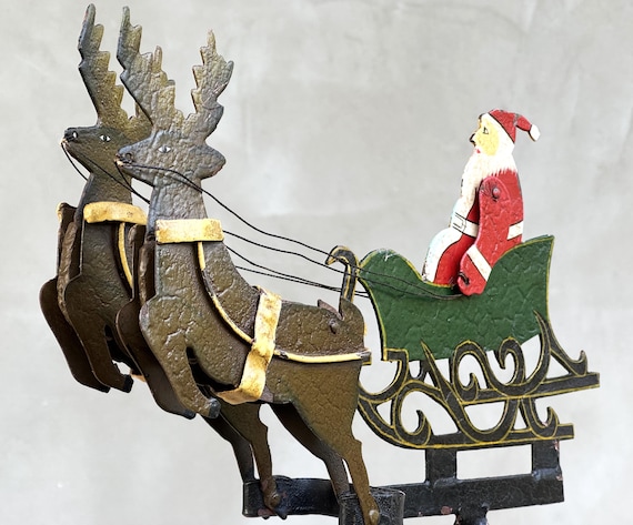 A vintage metal kinetic Santa and reindeer sleigh that actually balances and moves — holiday decor with genuine kinetic novelty and one-of-a-kind status.