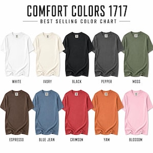 May include: A colour chart for Comfort Colors 1717 t-shirts featuring ten short-sleeve shirts in white, ivory, black, pepper, moss, espresso, blue jean, crimson, yam, and blossom. Each shirt is labelled with its corresponding colour name below it.