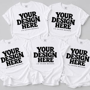 Pode incluir: Cinco camisetas brancas de manga curta dispostas em grupo. Cada camiseta apresenta o texto preto "YOUR DESIGN HERE" em uma fonte negrito e ondulada, com o texto menor "LIA GOLDEN MOCKUPS" impresso logo abaixo do gráfico principal.