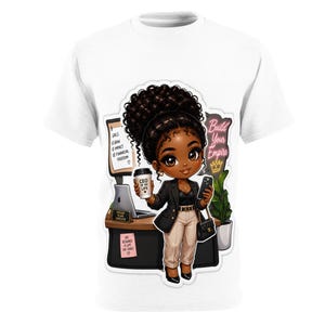 May include: A white t-shirt featuring a cartoon illustration of a professional with dark curly hair, wearing a black blazer and tan trousers. The character holds a coffee cup labeled CEO OF MY LIFE and a smartphone. Text includes Build Your Empire.