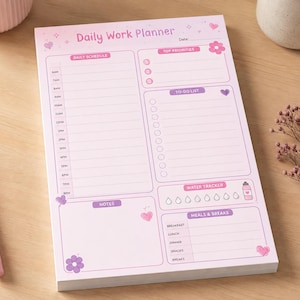 May include: A rectangular daily work planner notepad with a light pink background and purple text. The layout includes sections for a daily schedule, top priorities, a to-do list, a water tracker with eight water drop icons, notes, and meals.
