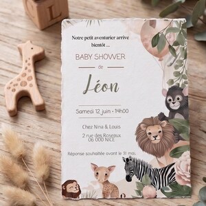 Peut inclure: Une carte d'invitation pour baby shower rectangulaire aux bords effilochés avec des illustrations de lion, zèbre, singe et faon. Le texte indique : Notre petit aventurier arrive bientôt... BABY SHOWER de Léon Samedi 12 juin 14h00 Chez Nina & Louis 2 rue des Roseaux 06 000 NICE Réponse souhaitée avant le 31 mai.