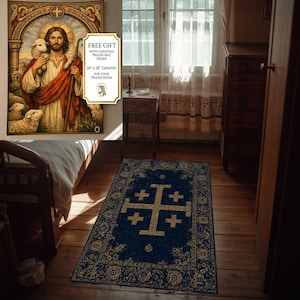 Puede incluir: Una alfombra de oración rectangular con fondo azul oscuro, una gran cruz de Jerusalén dorada en el centro y un borde dorado ornamentado. La alfombra se muestra sobre un suelo de madera en una habitación con un tapiz de un pastor.