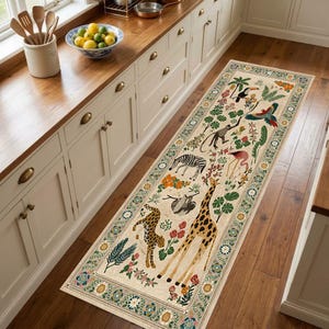 Peut inclure: Un long tapis de couloir rectangulaire au fond crème orné d'un imprimé jungle vibrant. Le motif présente des illustrations de girafe, léopard, zèbre, paresseux, singe, flamant rose, toucan et perroquet entourés d'une flore tropicale variée.