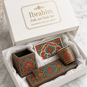 Pu&ograve; includere: Una scatola regalo bianca con l'etichetta Ibrahim Folk Art Desk Set contenente un portapenne quadrato, un vassoio rettangolare, una tazzina e un pezzo rettangolare piatto, tutti caratterizzati da intricati motivi floreali dipinti a mano in rosso, verde acqua e oro.