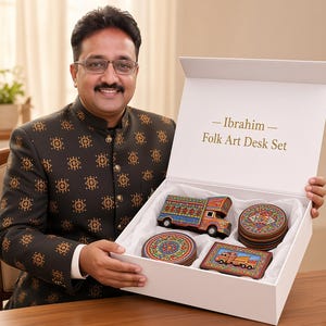 Pu&ograve; includere: Una scatola regalo bianca con l'etichetta Ibrahim Folk Art Desk Set contenente un camion in miniatura, un vassoio rettangolare con l'illustrazione di un camion e una pila di sottobicchieri circolari, tutti con motivi vivaci, multicolori e dipinti a mano.