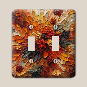 May include: A rectangular double light switch cover plate featuring a thick impasto oil painting design with vibrant shades of orange, red, yellow, brown, and dark gray. The surface displays visible textured brushstrokes and two toggle switch cutouts.