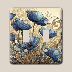 Puede incluir: Una placa de pared para interruptor doble con una ilustración detallada de flores de amapola azules con pétalos y centros de color azul oscuro, sobre un fondo de patrones de líneas en espiral de color crema y beige con acentos circulares.