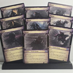 May include: A black display stand holding eight Nazgûl trading cards. Each card features a dark, illustrated scene of a cloaked figure on horseback, with the text Nazgûl, Creature - Wraith Knight, and game rules printed on the card face.