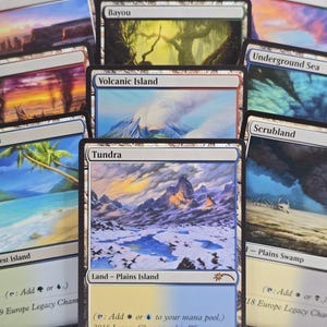 May include: A collection of Magic: The Gathering trading cards featuring land types including Plateau, Bayou, Badlands, Volcanic Island, Underground Sea, Tropical Island, Tundra, and Scrubland, each displaying unique landscape illustrations and text.