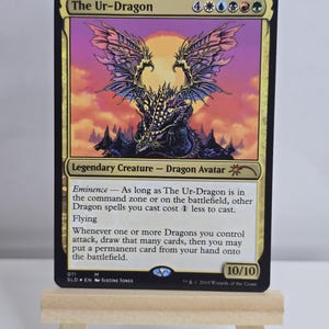 May include: A Magic: The Gathering trading card titled The Ur-Dragon, featuring a large, dark, winged dragon illustration against a sunset background. The card text includes the creature type Dragon Avatar, the power and toughness 10/10, and rules.