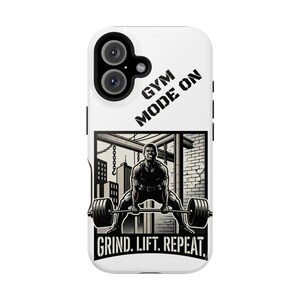 May include: White phone case featuring a black and white illustration of a weightlifter performing a deadlift. The text "GYM MODE ON" is at the top, and "GRIND. LIFT. REPEAT." is at the bottom. The case has a black camera lens.