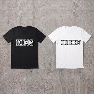 Könnte beinhalten: Ein schwarzes T-Shirt mit dem Wort KING in weißen Blockbuchstaben und ein weißes T-Shirt mit dem Wort QUEEN in schwarzen Blockbuchstaben. Beide T-Shirts haben kurze Ärmel und einen Rundhalsausschnitt in einem standardmäßigen Schnitt.