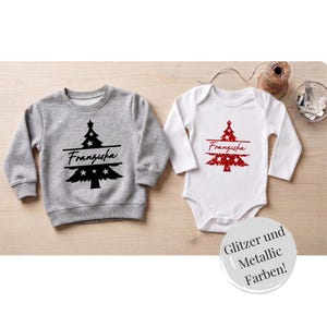 Könnte beinhalten: Ein graues Langarm-Sweatshirt und ein weißer Langarm-Body. Beide Kleidungsstücke zeigen eine Grafik eines Weihnachtsbaums mit einer horizontalen Linie in der Mitte, die den Namen Franziska in Schreibschrift enthält.