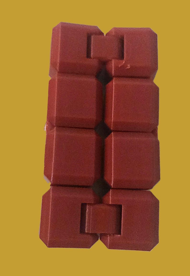 May include: A red, segmented fidget toy with a brick-like design. The toy is composed of several connected, rectangular blocks, each with a slightly beveled edge. The blocks are arranged in a vertical chain, allowing for flexible movement and manipulation.