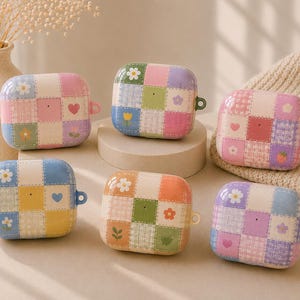 May include: Six rectangular protective cases for wireless earbuds, each featuring a colorful patchwork design with squares of plaid patterns, solid colors, and small floral, heart, or fruit motifs in pastel shades of pink, blue, green, and yellow.