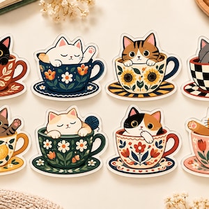 Puede incluir: Un conjunto de ocho pegatinas troqueladas que muestran varios gatos sentados dentro de tazas de té decorativas. Los gatos incluyen variedades negras, blancas, atigradas, grises, calicó y naranjas, cada una con tazas y platos a juego.