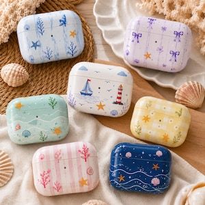 May include: Six rectangular wireless earbud cases featuring various patterns including nautical themes with sailboats and lighthouses, soft pastel stripes with coral and seashells, a yellow gingham floral print, and a dark blue ocean wave design.