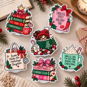 Pode incluir: Um conjunto de seis autocolantes com tema natalício, apresentando ilustrações de livros, canecas e sacos de pano. O texto inclui All Booked For Christmas, Endless Spicy Holiday TBR, Just One More Chapter, Books Make The Holidays Brighter, Christmas Book Club e Smells Like I'm Getting Books For Christmas.