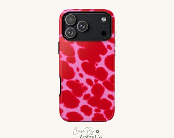 May include: A smartphone case featuring a vibrant red and pink cow print pattern. The back of the case includes a black camera module with three circular lenses and a flash. The text Case By ZizzyCo is printed at the bottom.