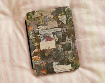 May include: A rectangular e-reader cover featuring a collage of fantasy-themed imagery, including a dragon, a deer, a goblet, and human hands. The text "THRONE OF GLASS" and "I will not be afraid" are printed on the cover in a neutral color palette.