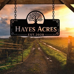 May include: A black metal rectangular sign hanging from two chains, featuring a laser-cut tree silhouette at the top, the text "HAYES ACRES" in the center, and "EST. 2020" at the bottom, with decorative scrollwork accents on the left and right sides.