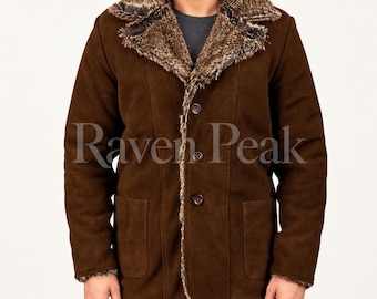 Könnte beinhalten: Eine braune Wildlederjacke mit breitem Kunstfellkragen und Revers, drei Knöpfen auf der Vorderseite und zwei großen aufgesetzten Taschen. Die Jacke hat lange Ärmel und eine strukturierte Oberfläche. Der Text Raven Peak ist mittig überlagert.