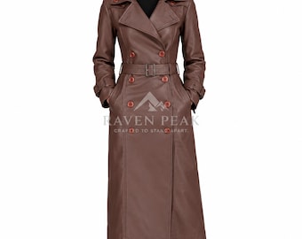 Könnte beinhalten: Ein langer brauner Ledertrenchcoat mit doppelreihiger Knopfleiste, passendem Taillengürtel mit Schnalle, breitem Revers und Schulterklappen. Der Text RAVEN PEAK CRAFTED TO STAND APART ist auf der Vorderseite des Mantels aufgedruckt.