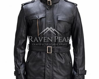 Könnte beinhalten: Eine schwarze Lederjacke mit hohem Kragen und Schnallenriemen, Knopfleiste vorne und passendem Taillengürtel mit Schnalle. Auf der Brust befindet sich der Schriftzug RAVEN PEAK CRAFTED TO STAND APART, ergänzt durch zwei Pattentaschen und Schulterklappen.