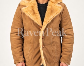 Könnte beinhalten: Eine hellbraune Wildlederjacke mit einem breiten, flauschigen Kunstfellkragen und Revers in einem helleren Goldbraun. Die Jacke hat drei braune Knöpfe auf der Vorderseite, lange Ärmel und zwei aufgesetzte Taschen. Der Text Raven Peak ist sichtbar.
