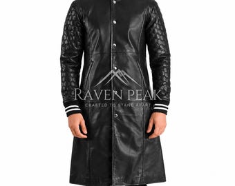 Könnte beinhalten: Ein langer Ledermantel in Schwarz mit einem Kragen im College-Stil mit weißen Streifen, Druckknopfverschluss und gesteppten Ärmeln. Auf der Brust steht der weiße Schriftzug RAVEN PEAK CRAFTED TO STAND APART mit Berggrafik.