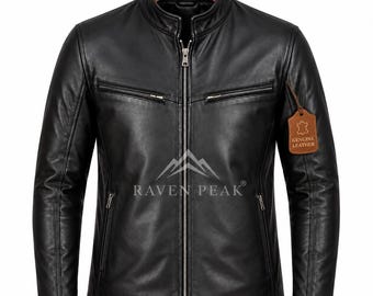 Könnte beinhalten: Eine schwarze Lederjacke mit Stehkragen, durchgehendem silberfarbenem Frontreißverschluss und zwei horizontalen Reißverschlusstaschen auf der Brust. Der Markenname RAVEN PEAK ist in Weiß gedruckt und ein braunes Lederetikett trägt die Aufschrift GENUINE LEATHER.
