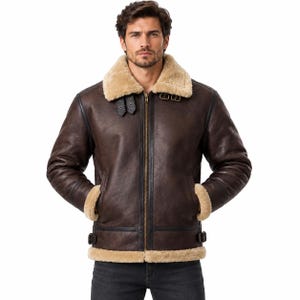 Puede incluir: Una chaqueta tipo aviador de cuero marr&oacute;n oscuro con cuello, pu&ntilde;os y dobladillo de borreguillo beige grueso. La prenda incluye una cremallera central en tono lat&oacute;n, dos correas con hebilla ajustables en el cuello y trabillas laterales.