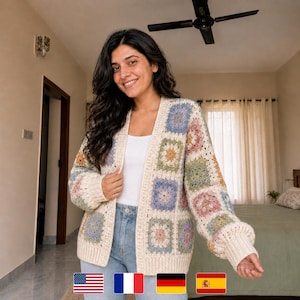 Könnte beinhalten: Cremefarbene Häkeljacke mit offenem Frontdesign und bunten quadratischen Mustern. Die Strickjacke weist eine Mischung aus Pastellfarben auf, darunter Blau, Gelb, Rosa und Grün. Die Ärmel sind lang und leicht gepufft. Die Strickjacke wird über einem weißen Oberteil und einer blauen Jeans getragen.