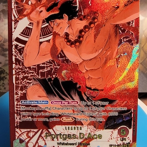 以下が含まれることがあります： ワンピースのポートガス・D・エースが描かれた、赤色のホログラフィック加工が施されたトレーディングカード。カードには炎を纏ったキャラクター、Portgas D. Ace、Whitebeard Piratesの文字、およびゲーム内の能力テキストが記載されています。