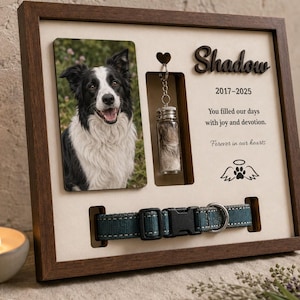 May include: A wooden memorial shadow box frame featuring a photo of a black and white dog, a small glass vial containing fur, and a teal dog collar. The text reads Shadow, 2017-2025, You filled our days with joy and devotion. Forever in our hearts.