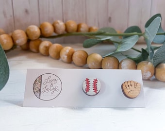 Peut inclure: Une paire de boucles d'oreilles en bois représentant un ballon de baseball et un gant de baseball. Les boucles d'oreilles sont sur une carte blanche avec le texte "Lucy & Leigh" imprimé dessus.