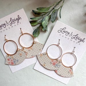 Könnte beinhalten: Zwei Paar Hängeohrringe auf weißen Lucy & Leigh Handmade-Präsentationskarten. Jeder Ohrring besteht aus einem goldfarbenen Metallring, der an einem fächerförmigen Stück beigefarbenem und weißem Vichy-Stoff mit kleinem Blumenmuster befestigt ist.