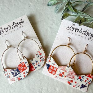 May include: Two pairs of hoop earrings on Lucy & Leigh Handmade display cards. One pair features silver-tone hoops with a white, red, and navy blue floral patchwork pattern. The other pair has gold-tone hoops with a matching floral patchwork design.