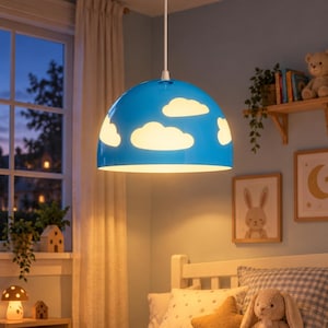 May include: A dome-shaped pendant light fixture with a bright blue exterior featuring white cloud-shaped cutouts that allow light to shine through. The lamp is suspended from the ceiling by a white cord and a matching white circular canopy.