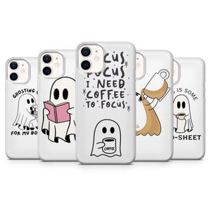 May include: Five clear phone cases featuring white ghost illustrations with black outlines. Designs include ghosts reading books, holding coffee mugs, and spilling coffee, with text reading "GHOSTING", "FOCUS I NEED COFFEE TO FOCUS", and "THIS IS SOME BOO-SHEET".