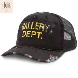 May include: A black trucker hat featuring the yellow text GALLERY DEPT. on the front panel. The hat has a distressed finish with small holes and paint splatters in blue, white, and red across the brim and crown, and a black mesh back panel.
