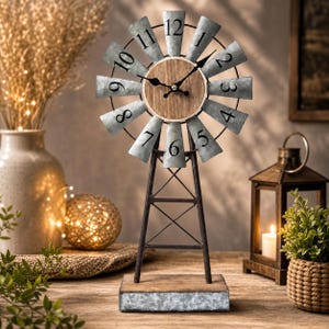 May include: A tabletop clock designed like a windmill with a circular wooden face, black numerals from 1 to 12, and metal blades. The clock is supported by a dark metal frame structure resting on a rectangular base made of wood and galvanized metal.