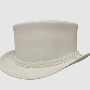May include: A solid white top hat featuring a tall, cylindrical crown and a curved brim. The base of the crown is encircled by a decorative braided band made of the same white material, providing a consistent monochromatic appearance throughout.