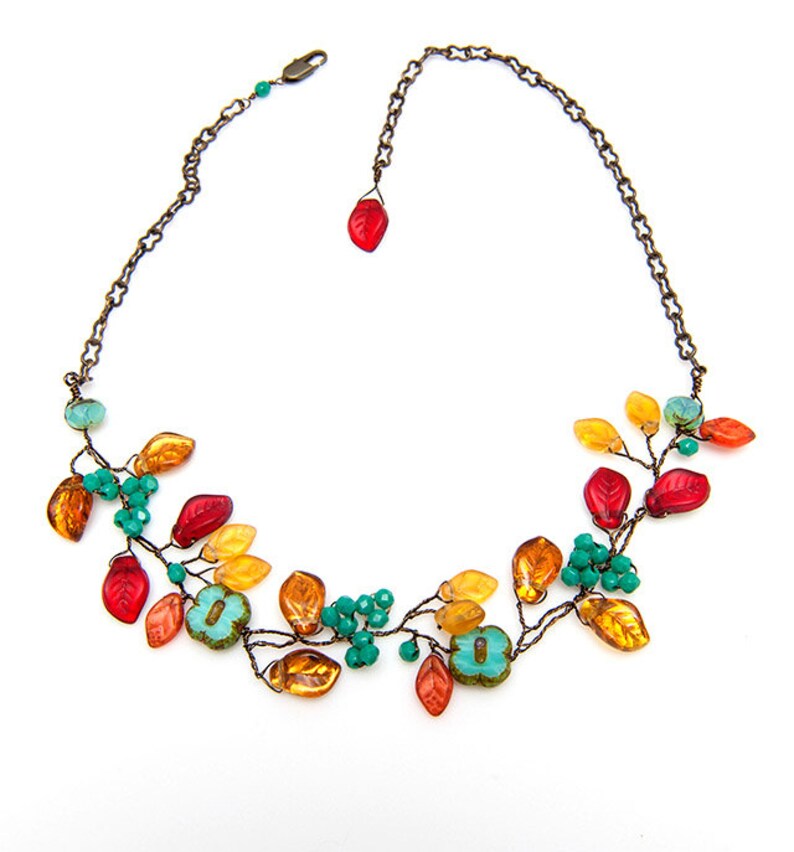 May include: A copper wire necklace with orange, red, and turquoise glass beads shaped like leaves.