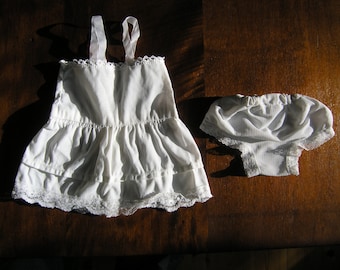 May include: A white cotton slip with lace trim and a matching pair of white cotton panties with lace trim.